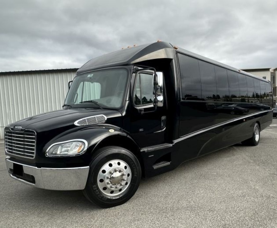 Black Freightliner 38-passenger party coach, three-quarter front
