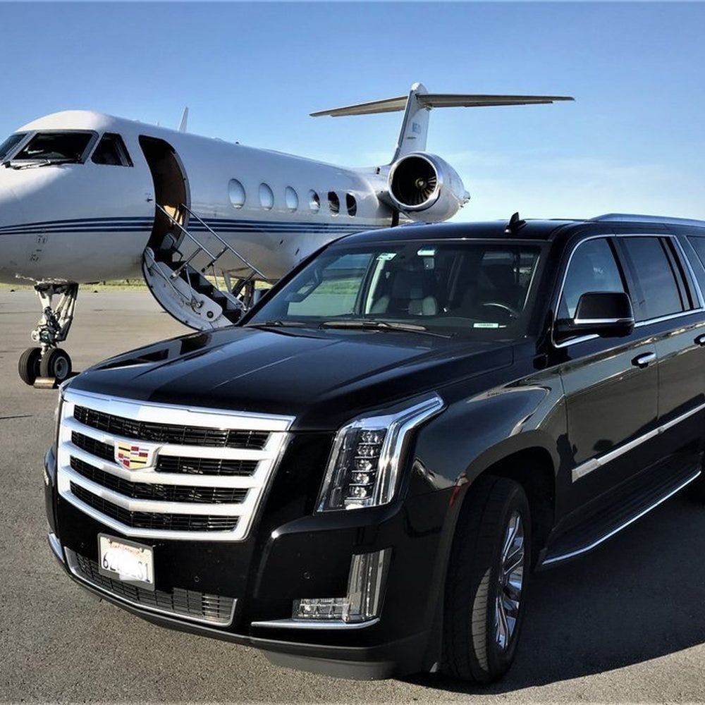 Black Cadillac Escalade beside a private jet on the tarmac